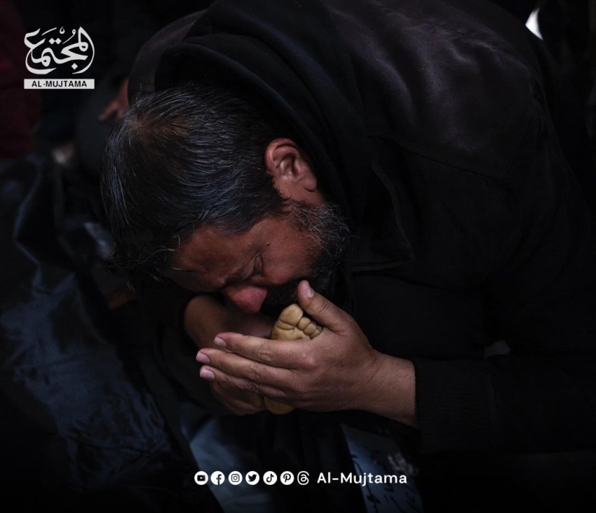 A Palestinian father kisses his dead child's feet, a victim of the continuous Israeli bombing of Rafah in southern Gaza.